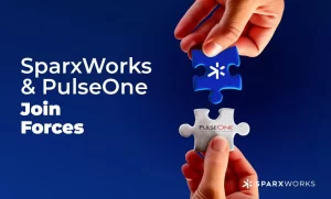 Two hands about to connect puzzle pieces with the SparxWorks and PulseOne logos. Text: 'SparxWorks & PulseOne Join Forces'.